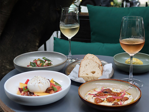 food plates with drinks at <yoastmarkhttps://wp.australiantraveller.com/wp-content/uploads/2024/08/Arms-Length.jpg 600w, https://wp.australiantraveller.com/wp-content/uploads/2024/08/Arms-Length.jpg?resize=249,187 249w, https://wp.australiantraveller.com/wp-content/uploads/2024/08/Arms-Length.jpg?resize=507,380 507w