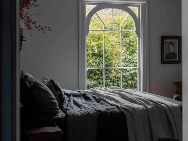 the bed with windows looking out the garden at Lumière Lodge 