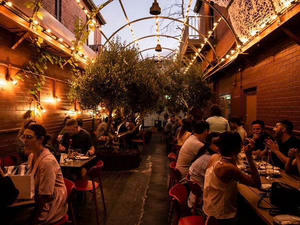 people dining in the dimly lit interior of Ode to Sirens