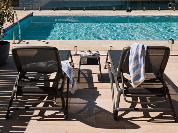 an outdoor pool with sun loungers at Rydges Hunter Valley
