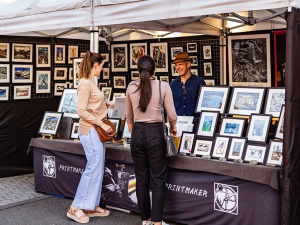 two women browsing a local arts and crafts stall at Salamanca Market