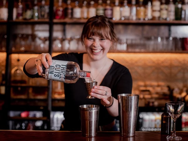 a female bartender shaking up drinks in Society Salamanca bar, Hobart