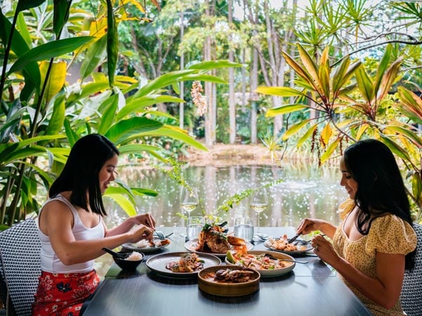 Two women dine by the water at Spirit House Restaurant