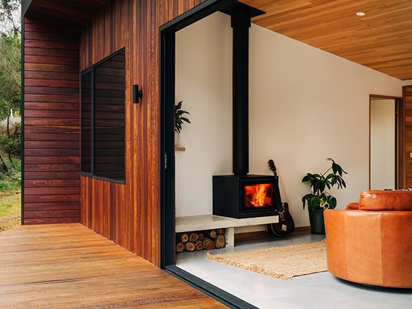 A modern wood cabin with a fireplace that can be found in an aussie tiny town airbnb