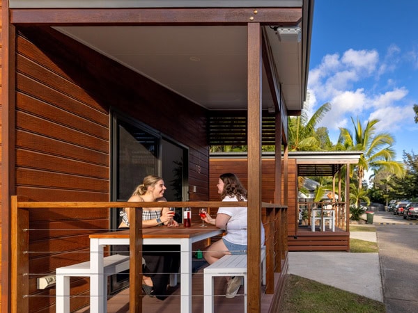 two women sitting outside a cabin at Big 4 Whitsundays Tropical Eco Resort