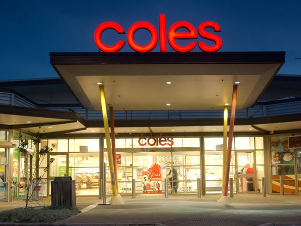 The entrance to a brightly lit Coles supermarket in Ropes Crossing at dusk.