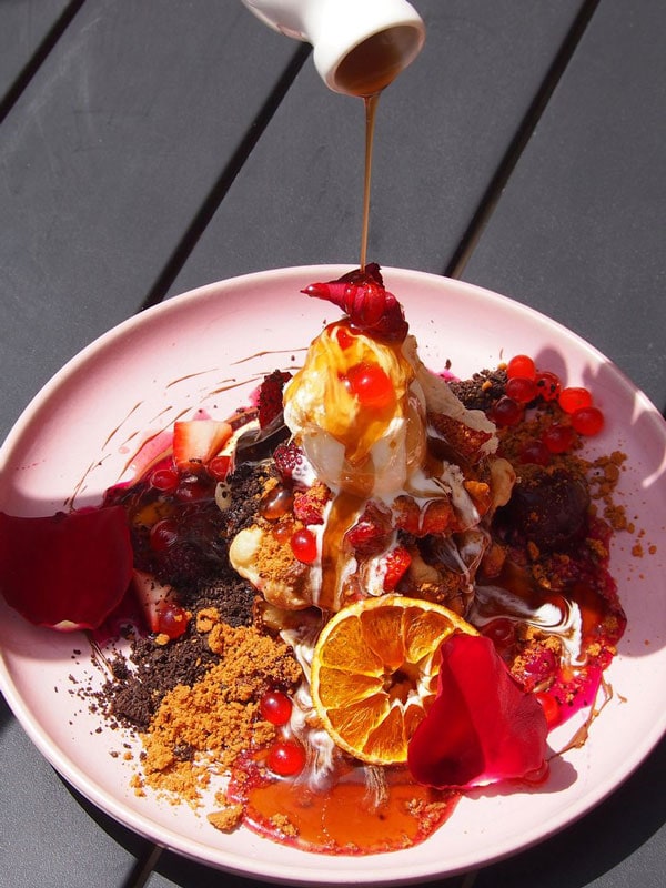 pouring sauce over a breakfast meal at Harrow and Harvest Cafe, Yarra Valley