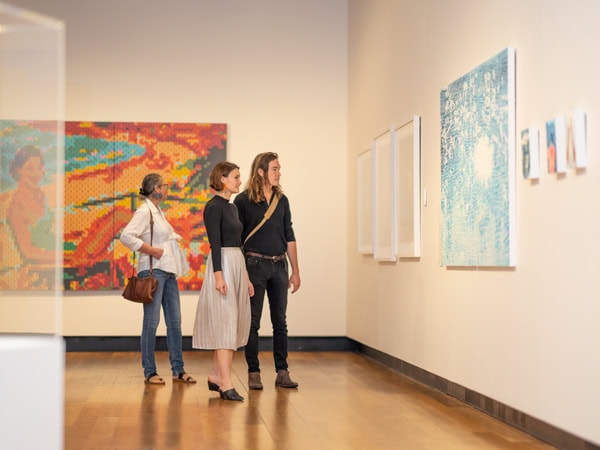 guests looking at paintings inside the Museum of Brisbane