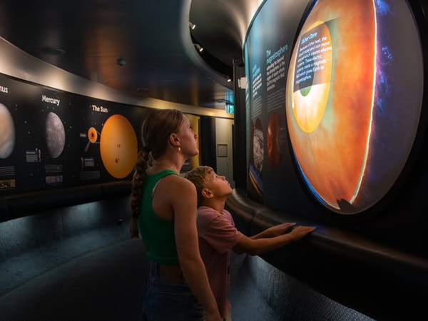 guests looking at interactive exhibits inside Sir Thomas Brisbane Planetarium 