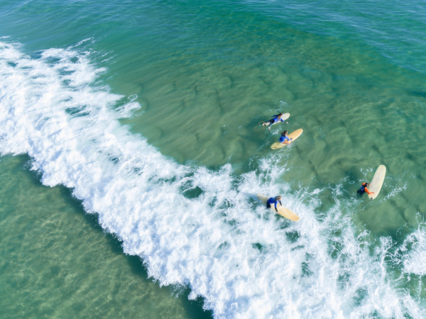 an aerial view of surfers at Main Beach in Byron Bay