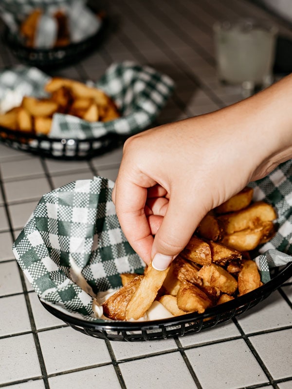 a hand picking finger foods from a platter at The Clam, Lorne