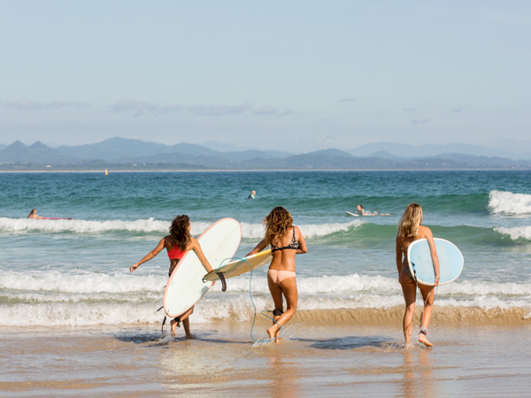 ladies heading to Wategos Beach for a surf