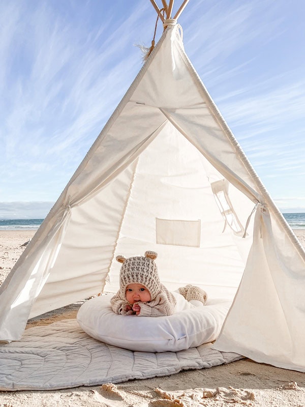 Cute baby lying in a cushii underneath a sun tent