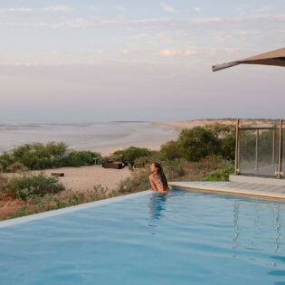 woman swims in the infinity pool at Eco Beach Resort Broome
