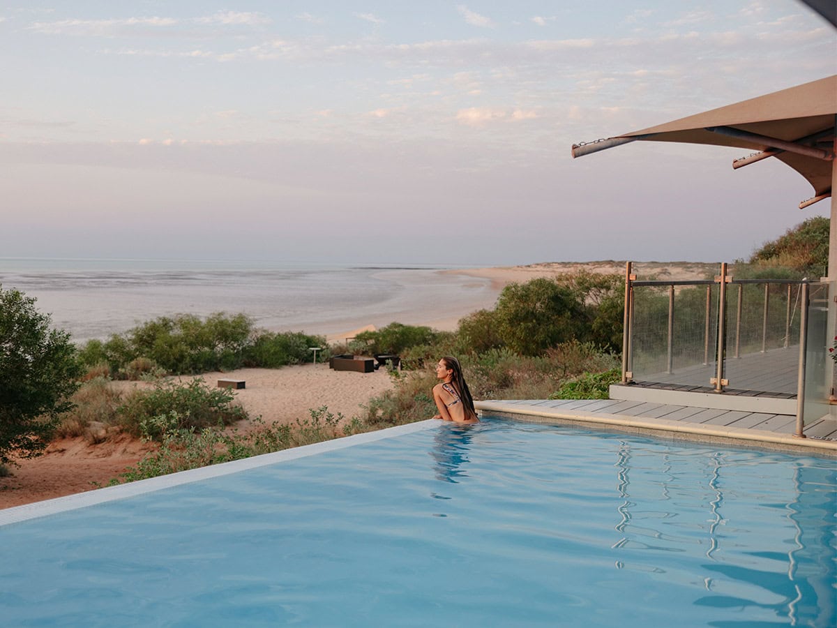 woman swims in the infinity pool at Eco Beach Resort Broome