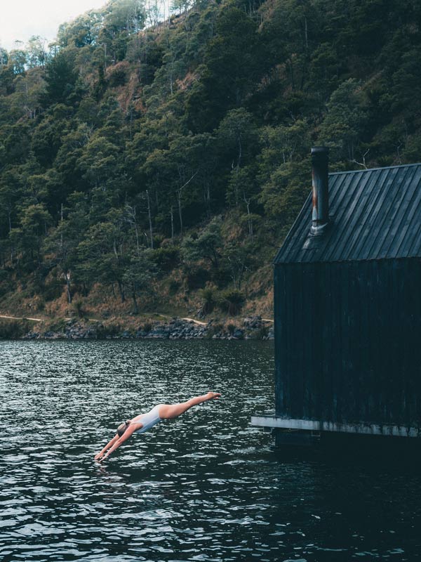 Woman diving from Floating Sauna Lake Derby, Tasmania