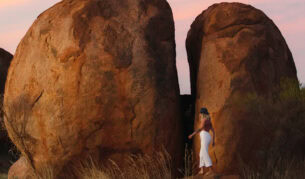 A woman standing in the Devil's Marbles.