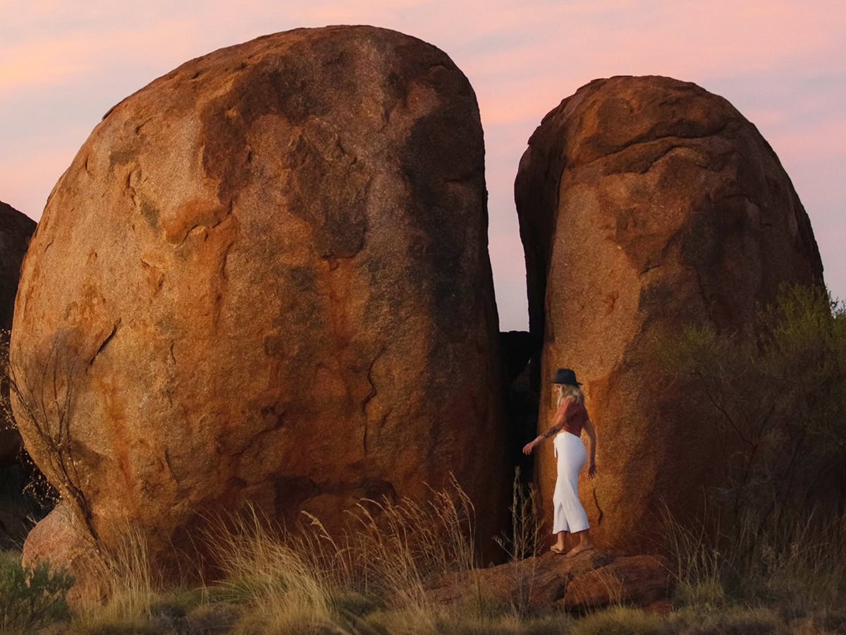 A woman standing in the Devil's Marbles.