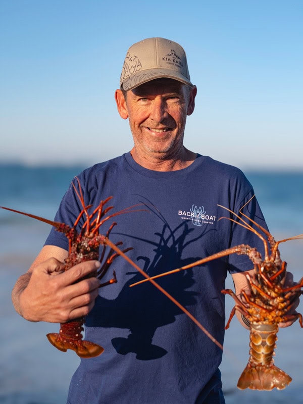 Cray fisherman Jay Barrett holding lobsters