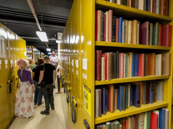 people wandering the bookshelves inside the National Library of Australia, Canberra