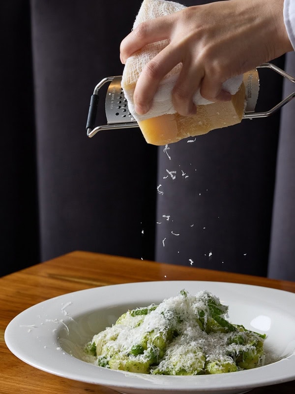 grating cheese on top of a dish at Persone, Brisbane