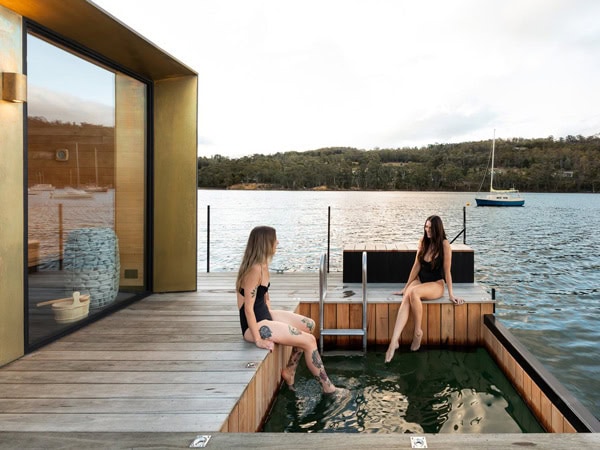 Two women dipping feet into hot tub at Sauna Boat Tasmania