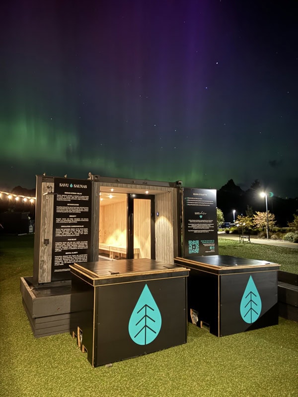 Savu Saunas in Tasmania with the southern lights (aurora australis) in the background