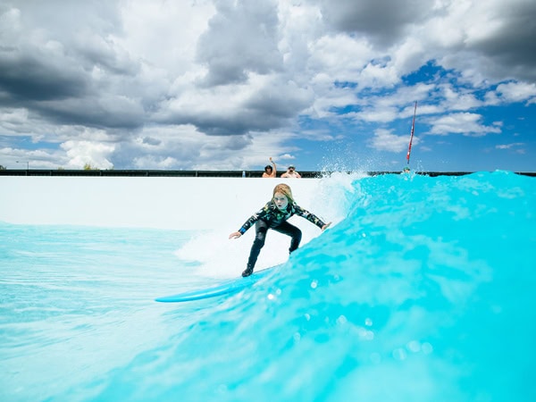 A child surfing in the ocean-like man-made waves.