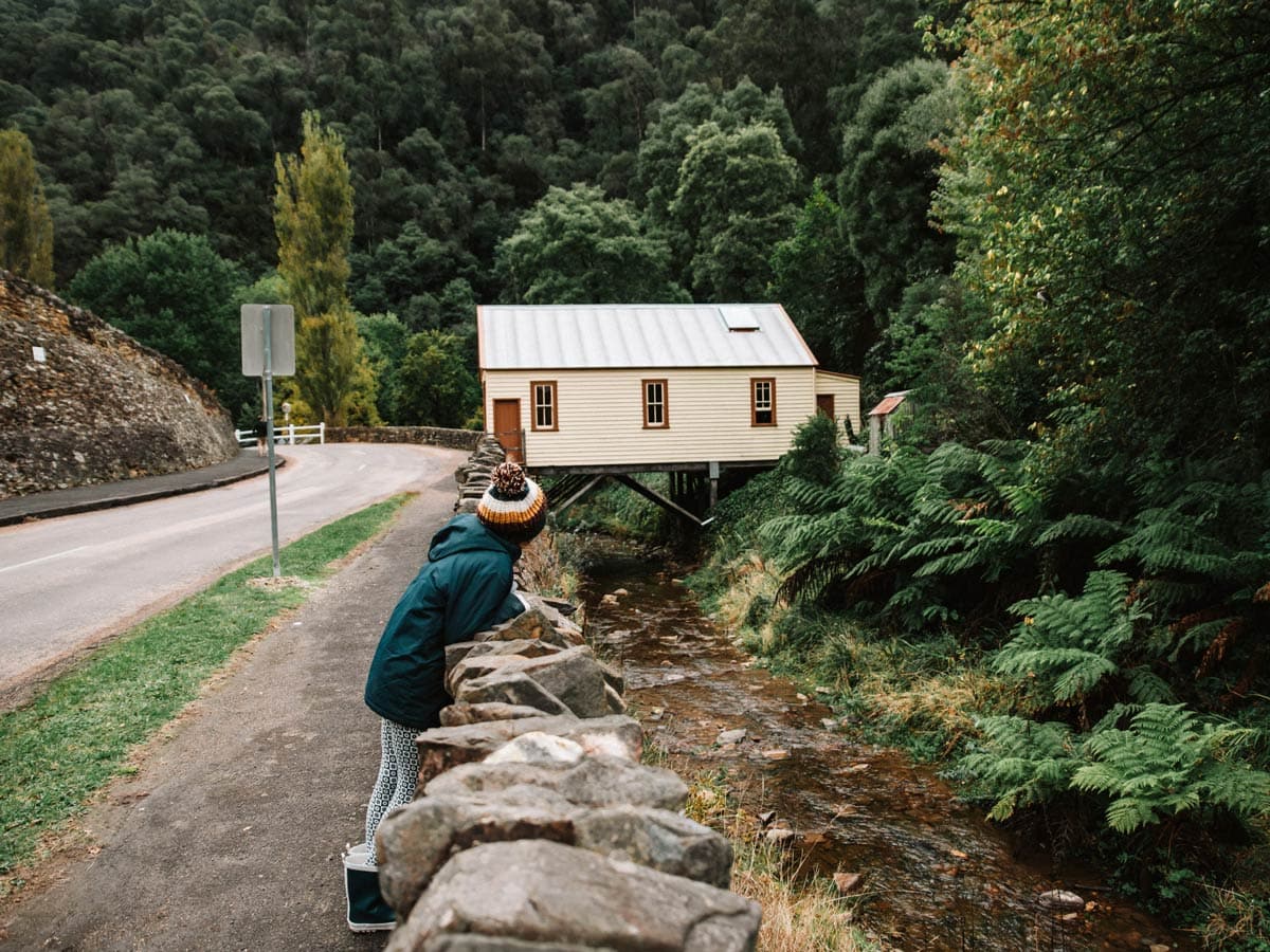 A woman on the edge of a road with Walhalla ghost town in the background