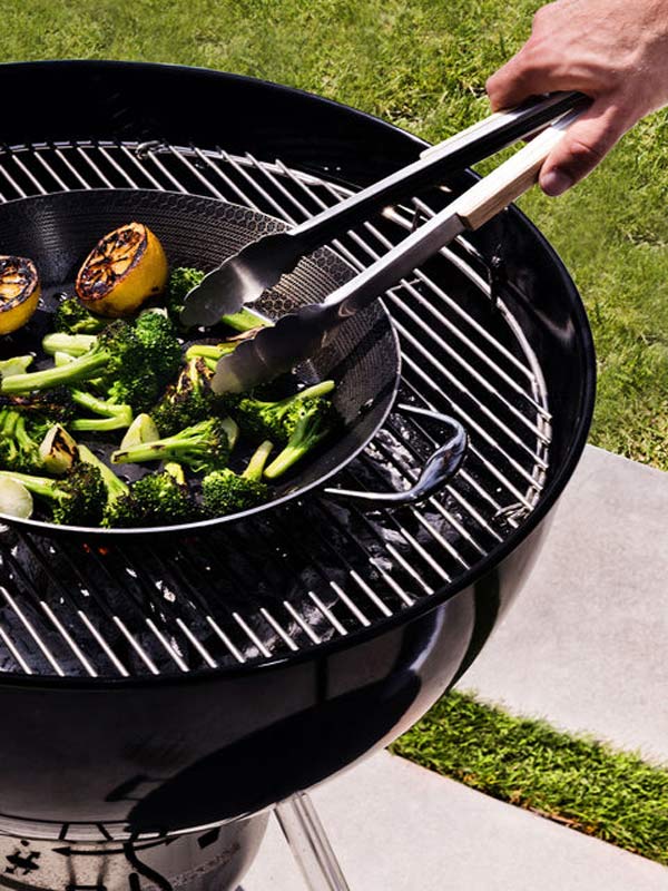 Close up of brocolli and charred lemon being prepared on the hexclad grill