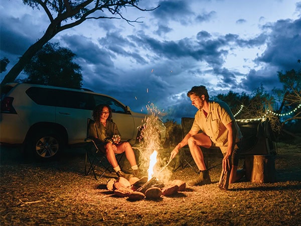 a couple around the campfire at Voyages Ayers Rock Resort