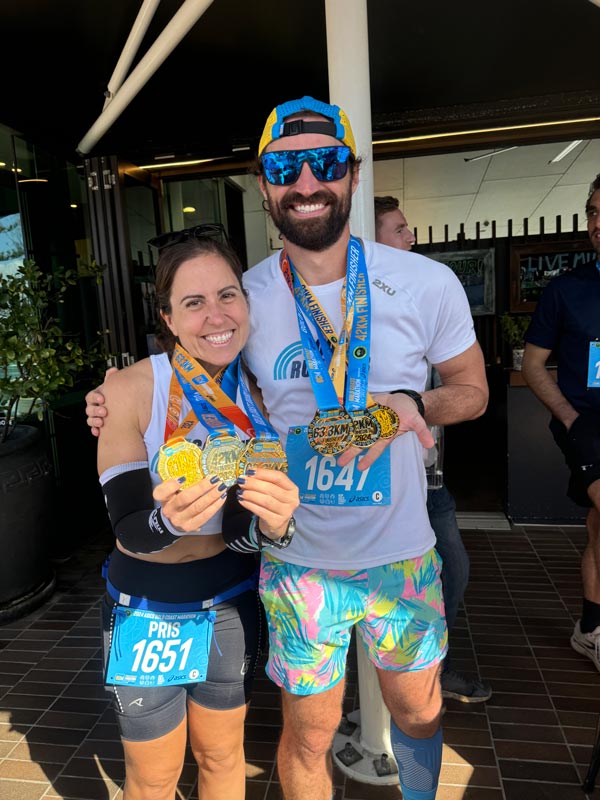 Coogee Run Club runners at the Gold Coast Marathon with their third medal for completing the half and full marathon