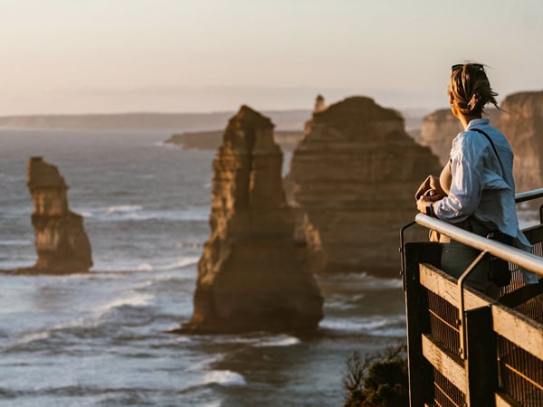 a woman looking out to the Twelve Apostles