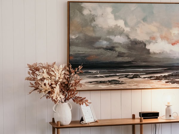 a painting mounted on the wall with a vase below at Sweet Tide O Moyne, Port Fairy