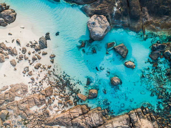 rocks dotting the clear blue waters of Boranup Beach