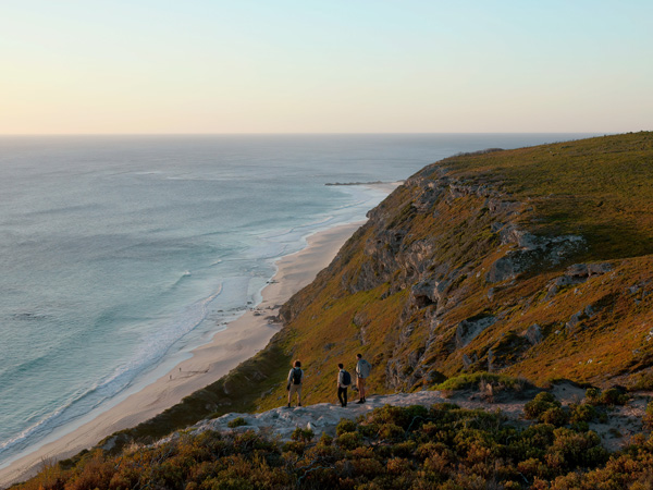 three people standing atop a hill overlooking Contos Beach, Boranup