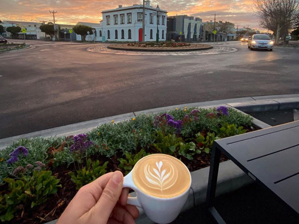 a hand holding a cup of latte at ToTo Town, Warrnambool