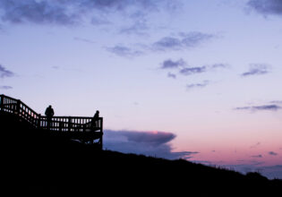 People watching the sun come up from a lookout