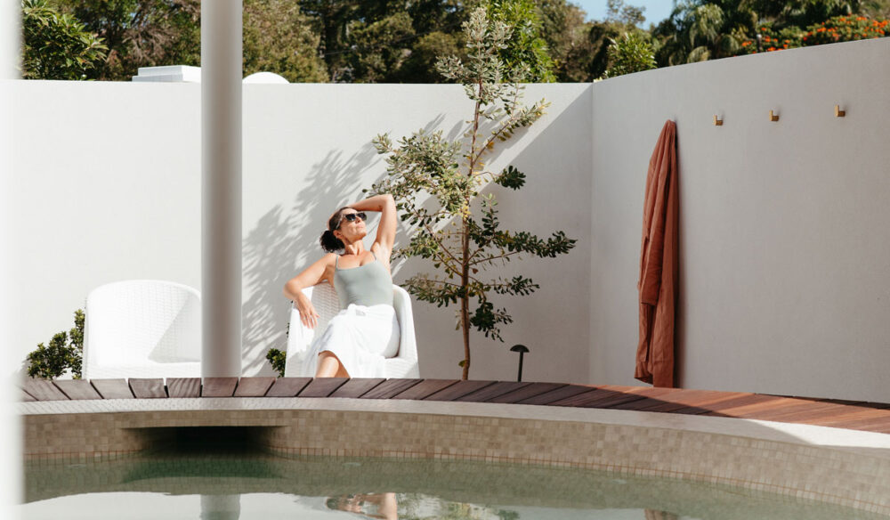 A woman relaxes beside the baths at Byron Bay Bathhouse