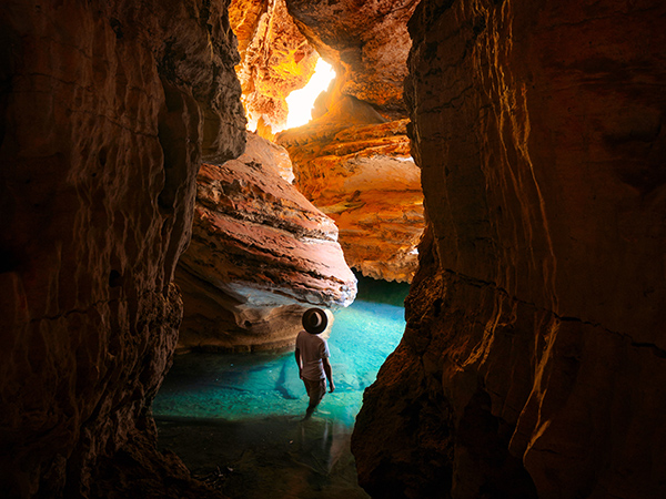 Eye-level view of traveller exploring Mimbi Caves.