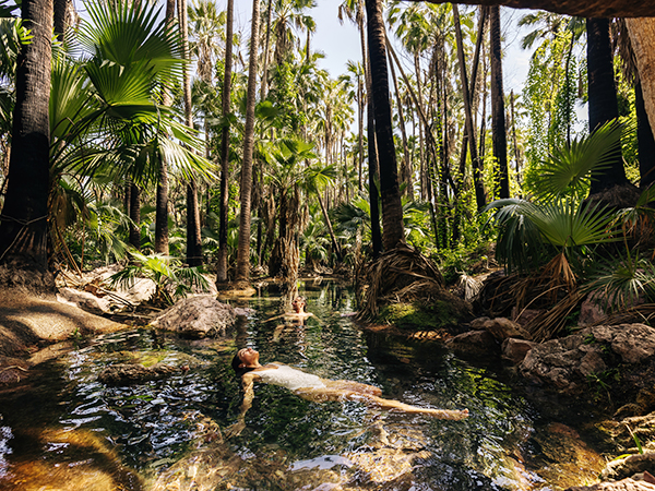 A person floats leisurely in the river at Discovery Holiday Parks, immersed in nature’s tranquillity.