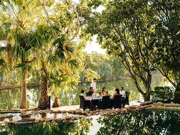A group of people enjoy an intimate dining experience at El Questro Homestead.