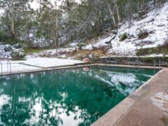 Hot spring pool with crystal clear water and snow covered ground nearby. Yarrangobilly thermal pool, Australia