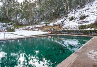 Hot spring pool with crystal clear water and snow covered ground nearby. Yarrangobilly thermal pool, Australia