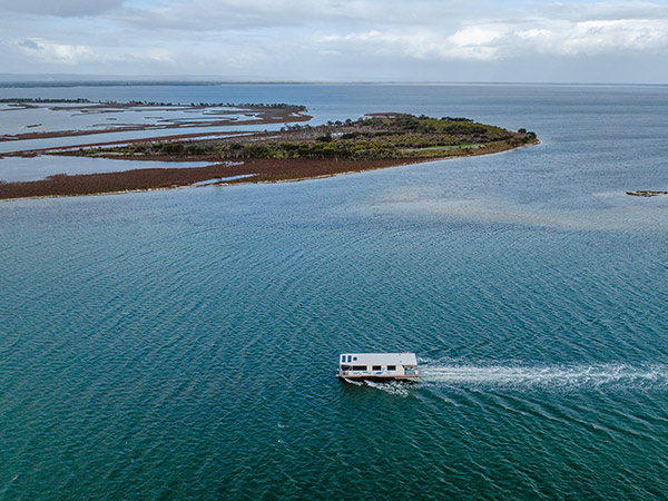 A houseboat cruising in Mandurah along the river