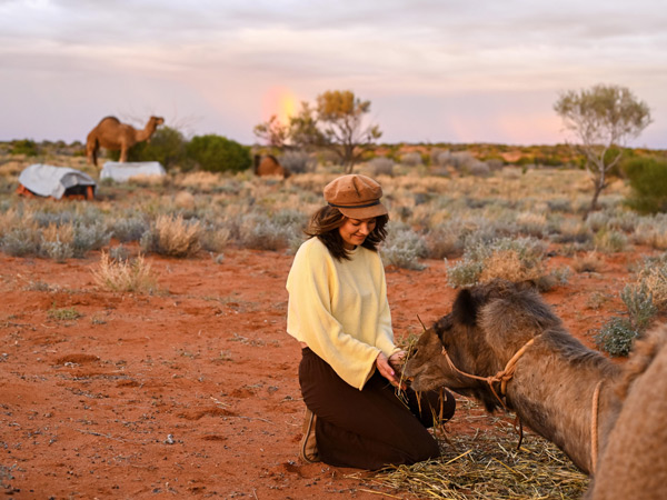 a woman petting a camel, Camel Treks Australia