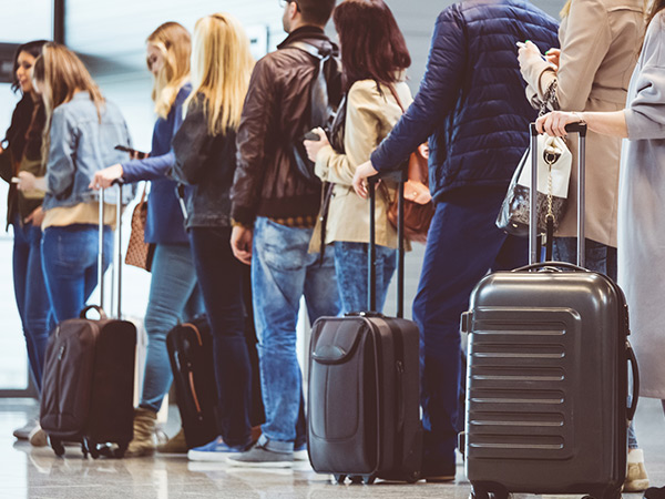 line of people with suitcases at airport