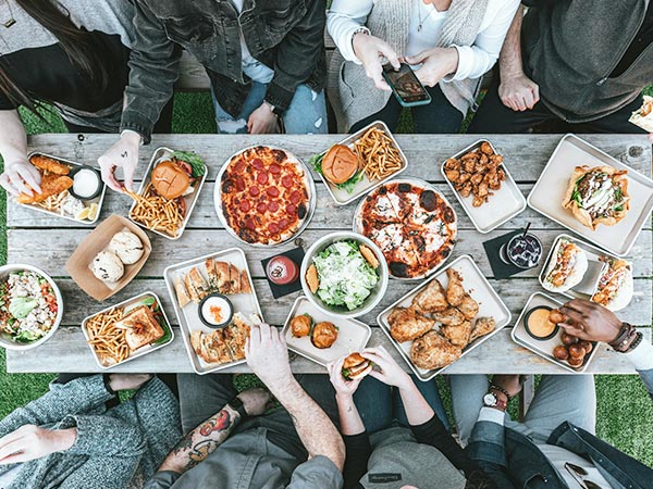 a group of people sitting around a table with food