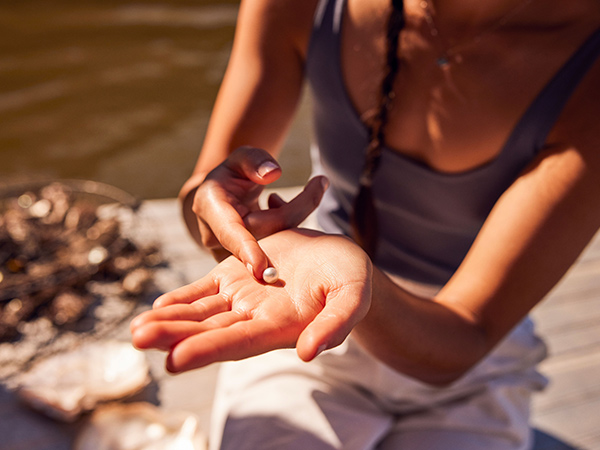 woman holding a pearl at Broken Bay Pearl Farm