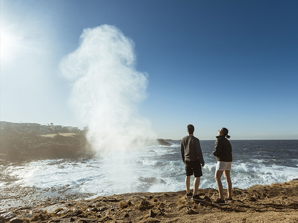 two people standing in front of kiama blowhole